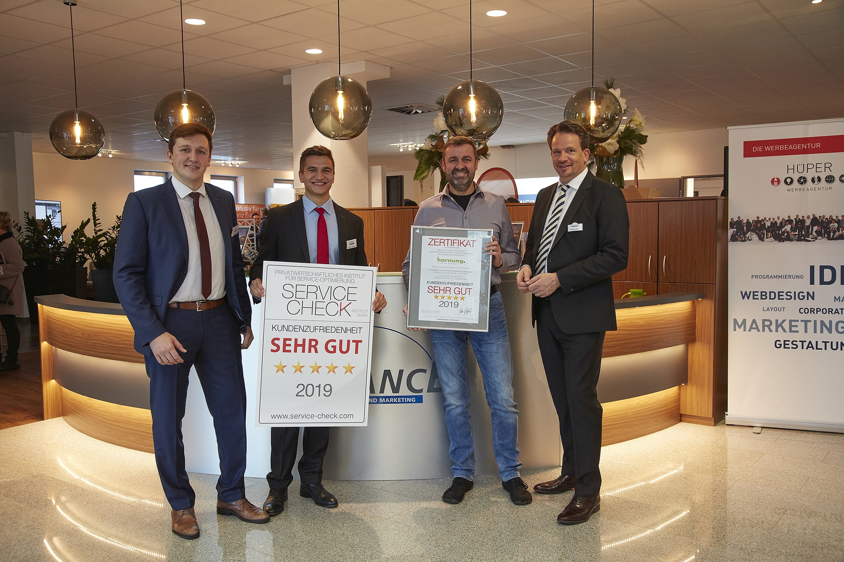 Herbert Hornung freut sich über die erneute Auszeichnung mit dem 5 Sterne SERVICE-CHECK-Siegel. Gleichzeitig danken er und auch das gesamte Möbel Hornung Team den mehr als 900 teilnehmenden Kunden für das hervorragende Votum. Personen von links nach rechts: erste Person von links - Maurice Piesker (Institut SERVICE-CHECK ), zweite Person von links - Pablo C. Gräfrath (Prokurist - Institut SERVICE-CHECK), dritte Person von links - Herbert Hornung (Geschäftsführer - Möbel Hornung), vierte Person von links - Thomas Eck (Geschäftsführer - Alliance-Verband)